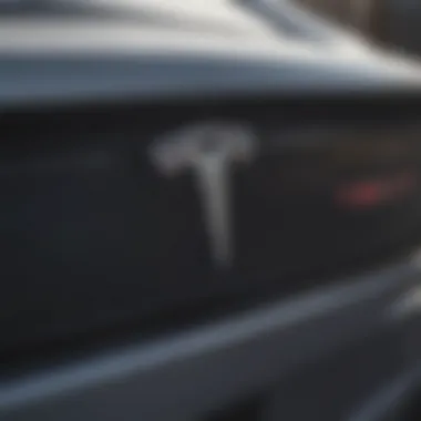 A close-up of the Tesla logo on a convertible car's exterior.