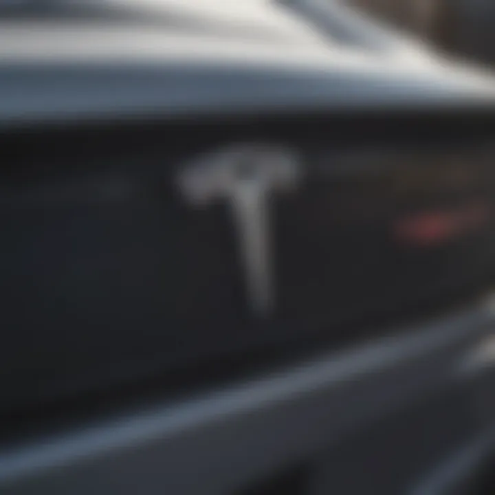 A close-up of the Tesla logo on a convertible car's exterior.